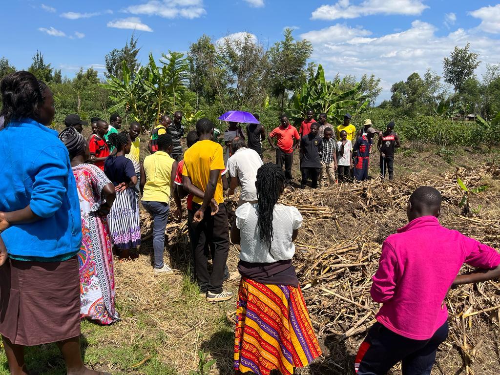 Group of black people standing around a field in a permaculture training